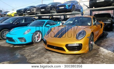 Moscow, Russia - May 09, 2019: Golden Porsche 911 Exclusive series. Limited edition. Number three hundred thirty seven. In the world were produced only 500 cars. Near parked blue 911 GT3 RS