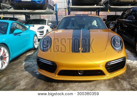 Moscow, Russia - May 09, 2019: Golden Porsche 911 Exclusive series. Limited edition. Number three hundred thirty seven. In the world were produced only 500 cars. Near parked blue 911 GT3 RS