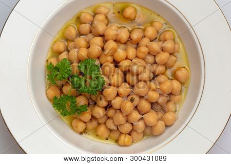 Greek chickpea soup (revithia soupa) garnished with parsley. It's made with olive oil, onion, water, oregano, garlic, bay leaf, lemon juice, flour and seasonings