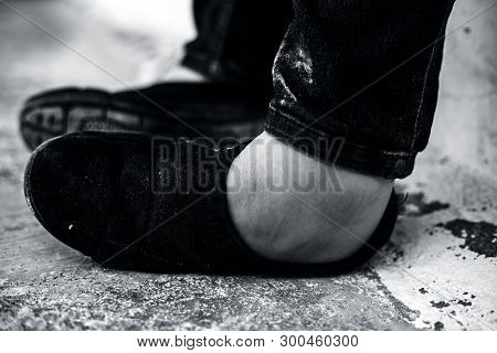 Women Legs Or Female Legs Shod In Black Colored Shoes And Blue Colored Jeans.