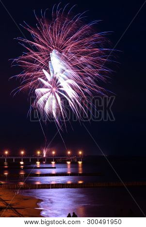 Two People, Man And Woman, Observe Fine Fireworks And Its Reflection In The Sea, The City Of Zelenog