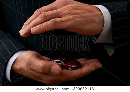 Insurance Agent Is Holding Car In Hands. Concept Of Auto Insurance