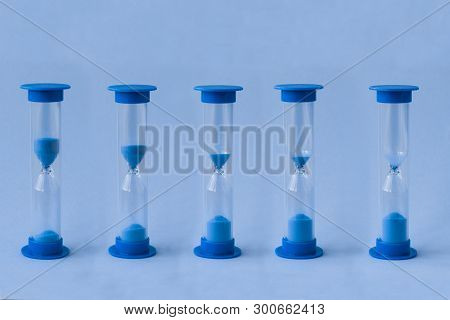 Row Of Sand Watches With Different Level Of Falling Sand Inside Of Them. Concept Of Running Time, Of