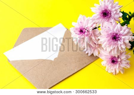Love Envelope With Blank Letter And Pink Chrysanthemum Flowers On Bright Yellow Bacground. Copy Spac