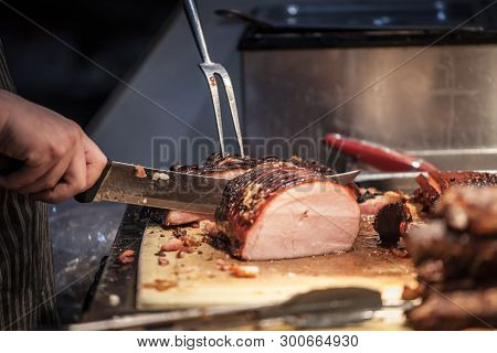 Canadian Bacon, Also Known As Peameal, For Sale, Grilled And Cooked, Being Cut Wuith A Knife On A Wo