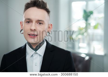 Portrait of alternative model with earplugs and tattoo