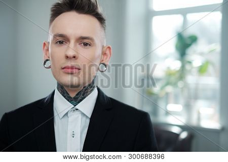 Portrait of alternative model with earplugs and tattoo