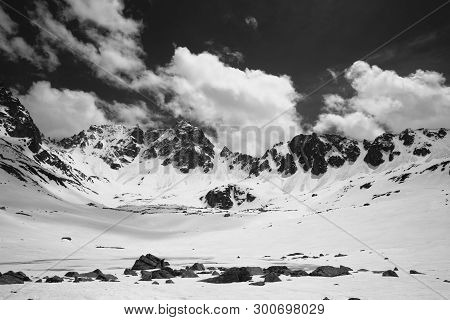 Plateau In High Snowy Mountains With Frozen Lake Covered Snow And Cloudy Sky At Sunny Spring Day. Tu