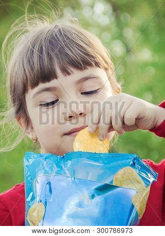 Child Eats Chips. Selective Focus. Food And Drink.