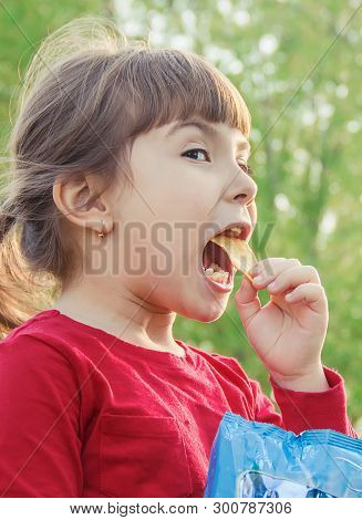 Child Eats Chips. Selective Focus. Food And Drink.