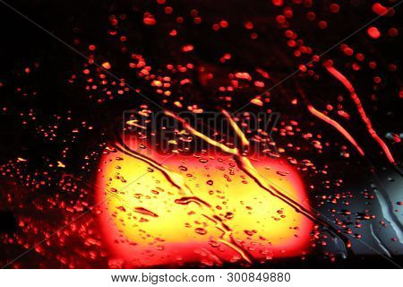 Traffic Is Viewed Through The Car's Windshield Covered In Rain, . Beautiful Background Of Rain And L
