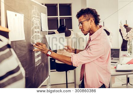 Fashion Designer Redrawing His Sketch On A Blackboard.