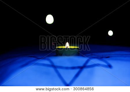 Candles Burning Over The Star Of David In Memory Of The Dead.