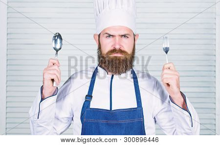 Time To Try Taste. Chef Serious Face Hold Spoon And Fork. Man Handsome With Beard Holds Kitchenware 