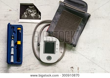 Ultrasound Picture Of The 20th Week Of Pregnancy And A Blood Pressure Monitor. Concept Of Danger Of 