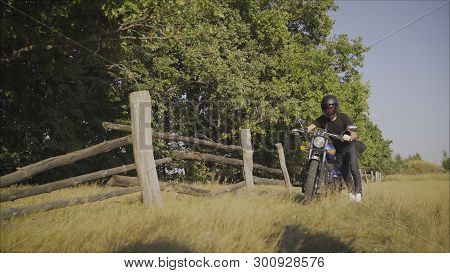 Motorcyclist Pulls A Broken Bike. Motorcyclist Rolls His Motorcycle. Motorcyclist Goes Near His Bike