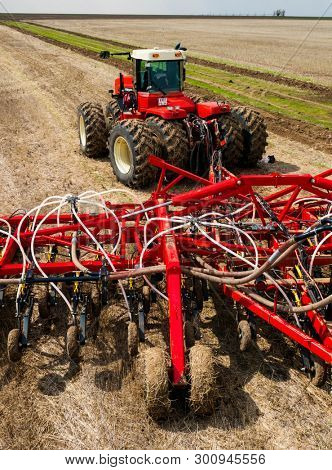 DECABRIST VILLAGE, SARATOV REGION, RUSSIA - 28 APRIL 2019: Sowing works on the wheat field. Planting complex - tractor and seeder mechanism