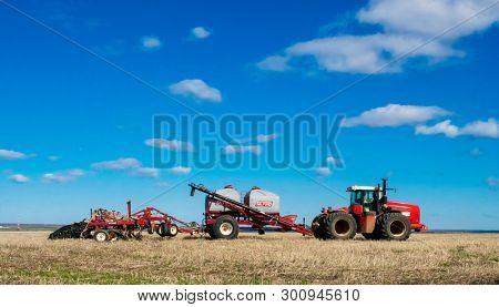 DECABRIST VILLAGE, SARATOV REGION, RUSSIA - 28 APRIL 2019: Sowing works on the wheat field. Planting complex - tractor and seeder mechanism