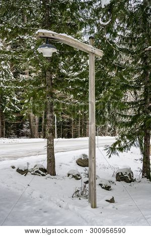 Wooden Lamp Post In The Snow Along A Snowy Road