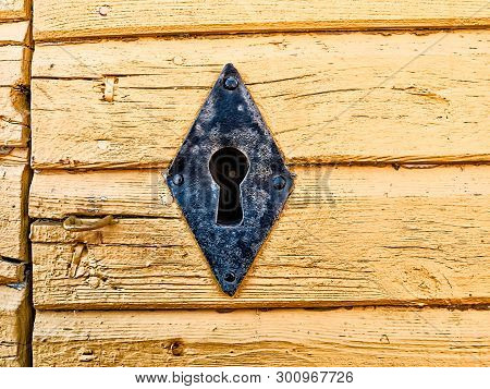 An Old Keyhole In A Wooden Wall Painted Yellow At The Old Town Of Kalajoki, Finland. The Metal Of Th