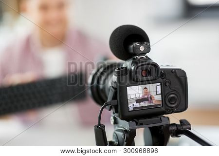 blogging, videoblog and people concept - camera recording male blogger video review of keyboard and computer mouse