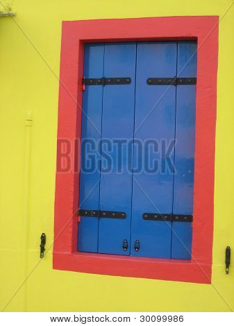 Vivid blue window with red and yellow wall