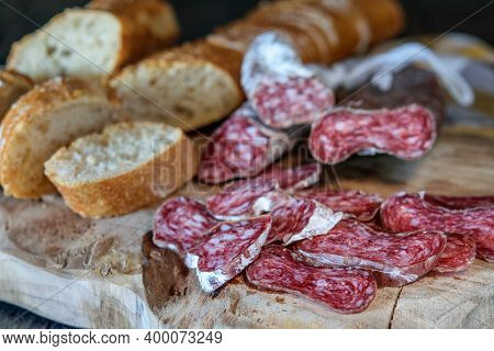 Slices Of Delicious Spanish Sausage Fuet And White Bread On The Rustic Kitchen Board Of Natural Wood
