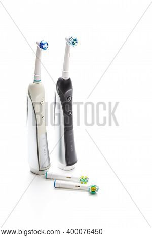 Dental Care Concepts. Two Professional Electric Toothbrushes In Front Of Four Manual Tooth Brushes O