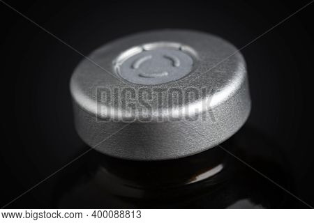 A Macro Shot With Selective Focus Of An Amber Color Vaccine Injection Bottle Set On A Dramatic Black