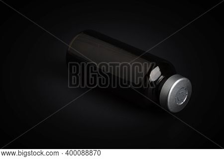 A Macro Shot With Selective Focus Of An Amber Color Vaccine Injection Bottle Set On A Dramatic Black