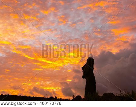 Statues Of Easter Island In The Background Of The Sunset. The Melting Of The Easter Statue In The Su