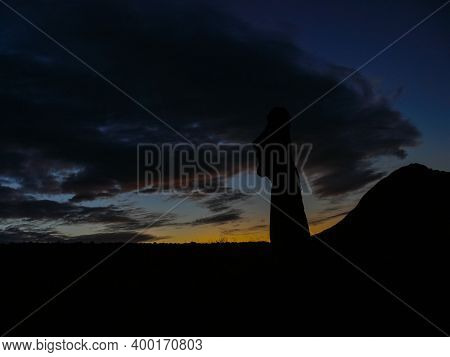 Statues Of Easter Island In The Background Of The Sunset. The Melting Of The Easter Statue In The Su