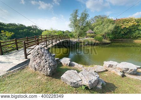 Pedestrian Wooden Bridge In The Park To The Island Across The River