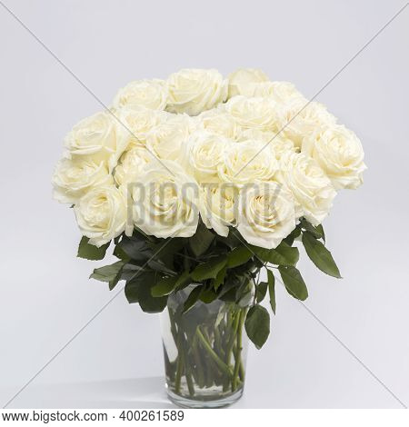 A Bouquet Of White Roses Playa Blanca Is In The Glass Vase On The Grey Background. Copy Space
