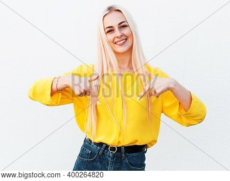 Cheerful Cute Woman Pointing Down At A Copyspace