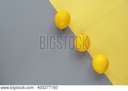 Lemons On Yellow And Gray Background. Trendy Colors 2021. Minimal Composition, Flat Lay, Copy Space.