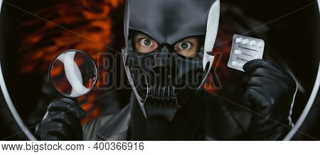 A Man Wearing A Demon Skull Mask In A Leather Cloak With A Magnifying Glass And Pills - Doctor Evil