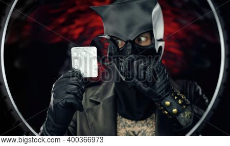 A Man Wearing A Demon Skull Mask In A Leather Cloak With A Magnifying Glass And Pills - Doctor Evil