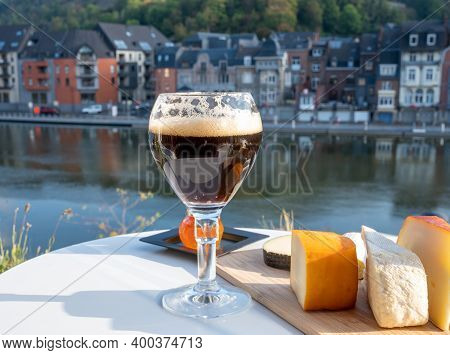 Drinking Of Dark And Strong Belgian Abbey Beer With Cheeses With Nice View On Maas River And Town Di