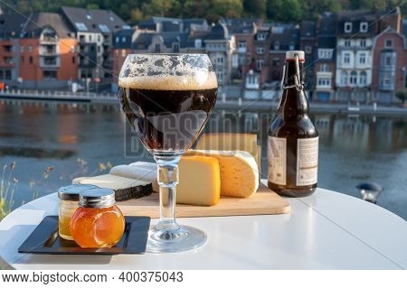 Drinking Of Dark And Strong Belgian Abbey Beer With Cheeses With Nice View On Maas River And Town Di