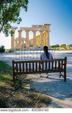 A Couple Visit Greek Temples At Selinunte During Vacation, View On Sea And Ruins Of Greek Columns In