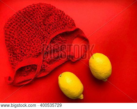 Red String Bag With Yellow Lemons. Vitamin C. Yellow And Red Color. Lemons In A Red String Bag On A 