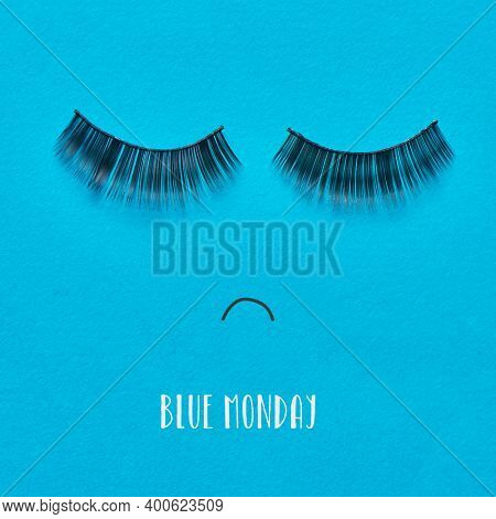 the text blue monday and a pair of fake eyelashes and a mouth drawn on a blue background forming a sad face