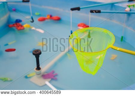 Fishing In The Paddling Pool. Childrens Toys In The Pool. Toy Fish Fishing Rod. Cheerful Children Fi