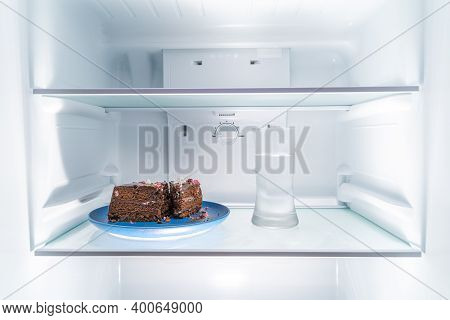 Chocolate Cake On A Blue Plate And A Glass Of Water Placed In A Clean Refridgerator, Diet Or Food Co