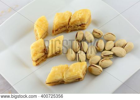 Pieces Of Baklava Dessert With Pistachio Nuts On White Snack Plate