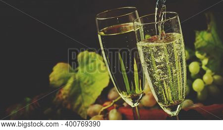 Champagne Pour In Glass, Grapes With Vine, Vintage Wood Background, Selective Focus And Toned Image
