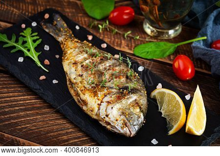 Grilled Dorado Fish On Wooden Background. Roasted Seafish With Spice And Herbs