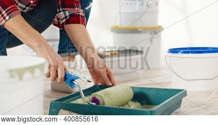 Young Beautiful Caucasian Cheerful Woman In Good Mood Preparing Paint For Painting Walls In New Apar