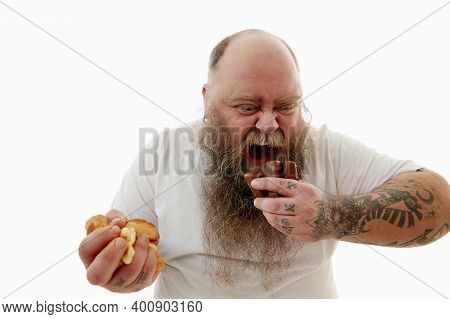 An Overweigh Caucasian Bearded Man In White T-shirt Consuming Unhealthy But Delicious Junk Food. Wil